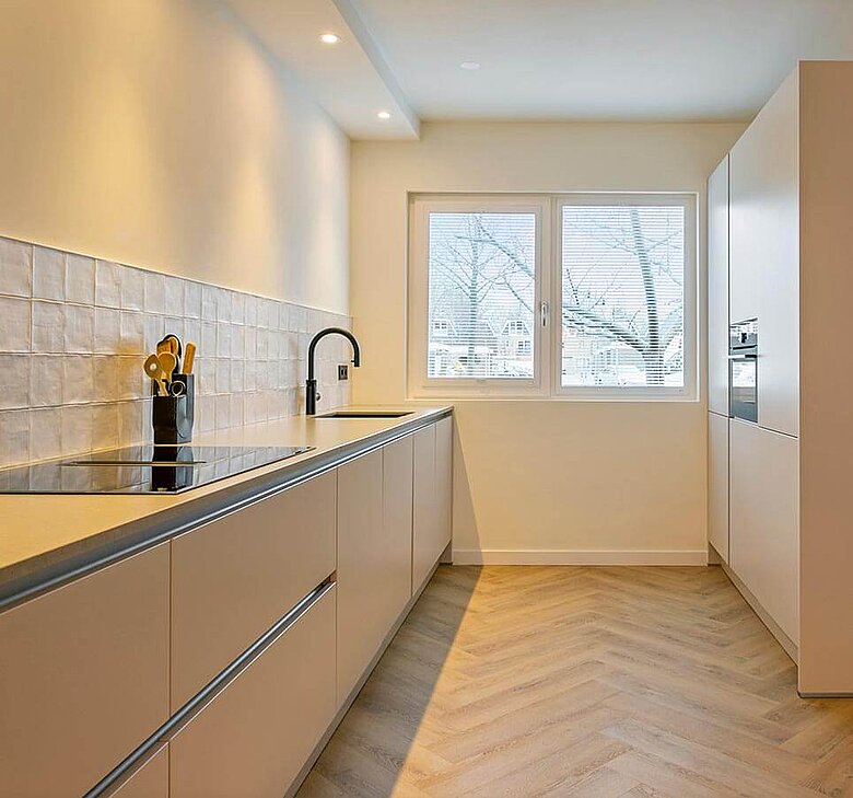 Moderne witte keuken met kastenwand